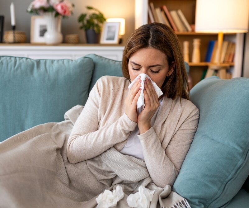 Sick,Woman,Blowing,Her,Nose,With,A,Tissue,On,A